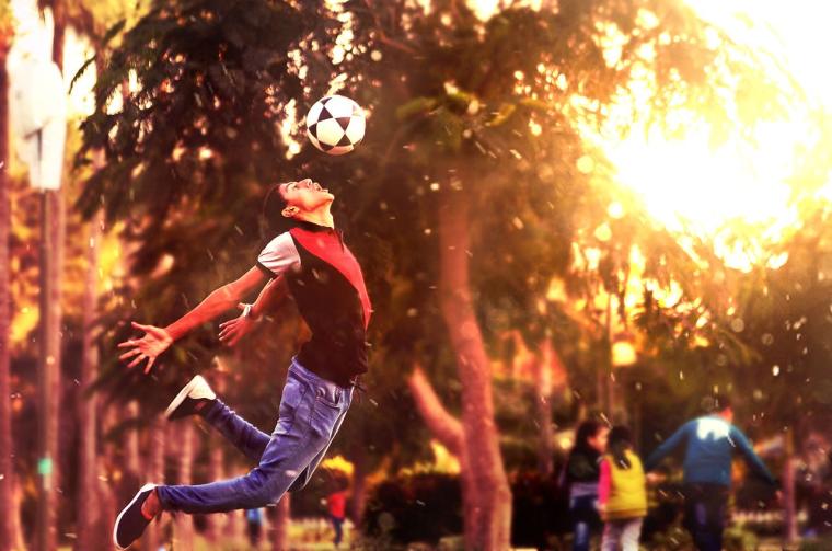 A young man jumps up for a header